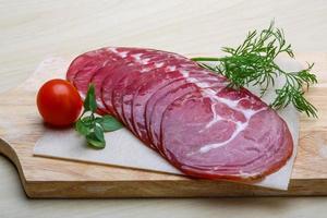 Sliced Ham on wooden plate and white background photo
