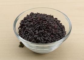 Black rice in a bowl on wooden background photo