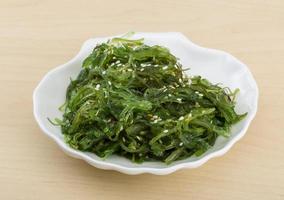 Chuka salad on the plate and wooden background photo