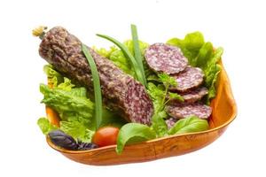 Ripe salami with salad, basil, onion and tomato photo