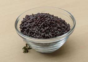 Black rice in a bowl on wooden background photo