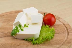 Feta cheese on wooden background photo