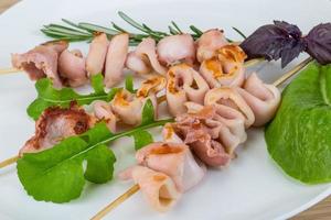 Grilled squid on the plate and wooden background photo