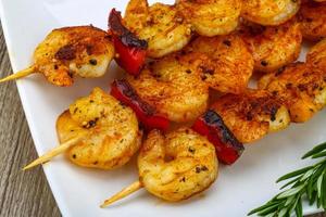 Prawn skewer on the plate and wooden background photo