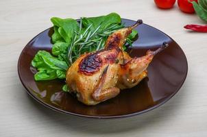 Roasted Quail on the plate and wooden background photo