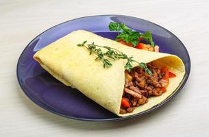 burrito en el plato y fondo de madera foto