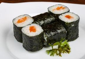 Salmon roll on the plate and wooden background photo