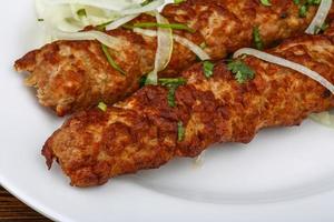 Beef kebab on the plate and wooden background photo