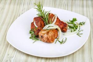 Shashlik on the plate and wooden background photo