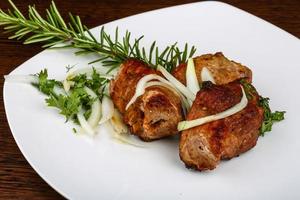 Grilled pork on the plate and wooden background photo