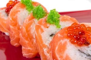 sushi japonés comida tradicional japonesa.rollo de salmón, cavair rojo, huevas y nata foto