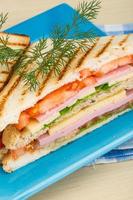 sándwich de club en el plato y fondo de madera foto