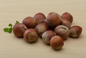 Hazelnut heap on wooden background photo