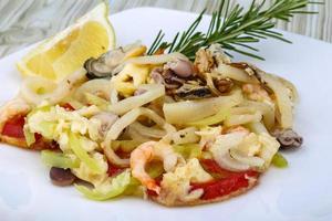 Seafood cocktail on the plate and wooden background photo