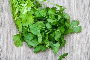 Coriander leaves on wooden background photo