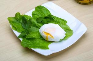 Egg benedict on the plate and wooden background photo