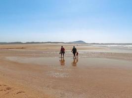 las personas caminan en la playa de valdovino. valdovino, galicia, españa foto