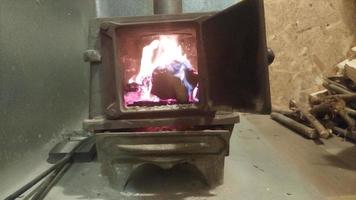 Firewood burning in a cast-iron stove warming the house