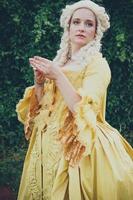 Portrait of blonde woman dressed in historical Baroque clothes with old fashion hairstyle, outdoors. photo