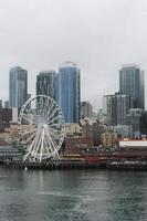 seattles  USA - March, 10 2022  Tall buildings, steam fumes, the seattles in the city The Seattle Great Wheal ferry terminal area. photo