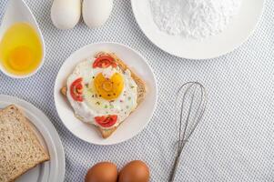 Bread placed with a fried egg with tomatoes, tapioca flour. photo