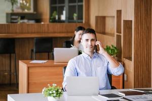 gerente de marketing masculino que usa el teléfono para hablar con una empresa de capital de riesgo para aumentar el potencial de ganancias. foto