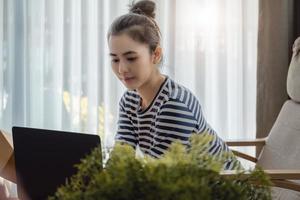 trabajar desde casa. las mujeres felices que venden productos en línea inician una pequeña empresa usando una computadora portátil para calcular los precios y prepararse para el franqueo. foto