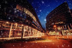 panorama de la ciudad nocturna de dusseldorf en invierno durante una tormenta de nieve. efecto de luz bokeh, filtro suave foto