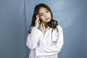 A portrait of a young Asian female doctor looks tired and overworked photo