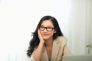 A woman in an office, working at a laptop computer. photo