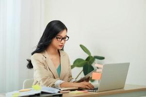 Smiling woman with laptop in home office photo