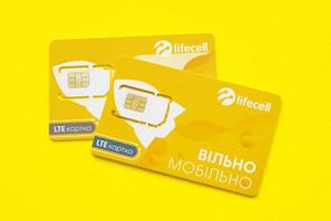 TERNOPIL, UKRAINE - JULY 5, 2022 Lifecell new sim card with free contract on yellow background. Lifecell is ukrainian mobile telephone network operator and provider of wireless connection photo