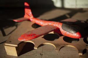 avión de juguete de material ligero. avión rojo juguete para niños en la mesa. foto