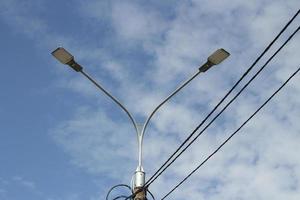 Street light during day. Pole with lamp. Urban electricity. photo