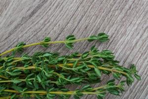 Thyme branch on wooden background photo