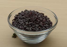 Black rice in a bowl on wooden background photo