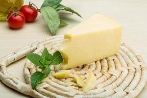 Parmesan cheese on wooden board and wooden background photo