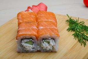 Philadelphia roll on wooden board and wooden background photo