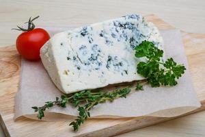 queso azul sobre tabla de madera y fondo de madera foto