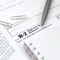 el bolígrafo y el cuaderno en el formulario de impuestos w-2 declaración de salarios e impuestos. la hora de pagar impuestos foto