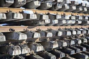 A lot of old rails and sleepers are stacked in a railway warehouse in winter. The concept of renewing a worn-out railway track photo