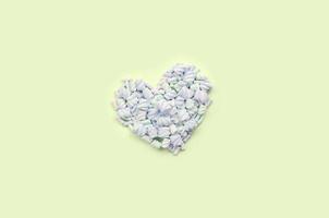 Colorful marshmallow laid out on lime and pink paper background. pastel creative textured heart photo