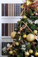 A beautiful decorated Christmas tree on the background of a bookshelf with many books of different colors. Christmas background image of the library photo