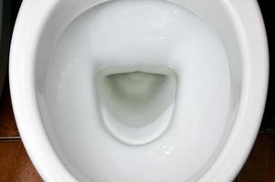 una fotografía de un inodoro de cerámica blanca en el vestidor o baño. Sanitarios de cerámica para corrección de necesidades. foto