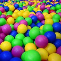 Many colorful plastic balls in a kids' ballpit at a playground. Close up pattern photo