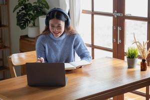 Relax, de-stress, relax, have fun. Asian women take notes of their past and record video clips on their laptops at home. photo