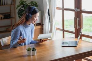 Relax, de-stress, relax, have fun. Asian women take notes of their past and record video clips on their laptops at home. photo