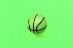 Small green ball for basketball sport game lies on texture background photo
