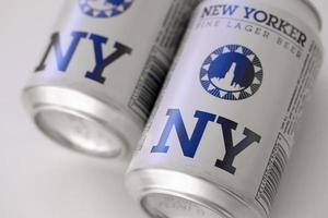 TERNOPIL, UKRAINE - JULY 18, 2022 Two cans of New Yorker fine lager beer with original logo and design on white paper background photo
