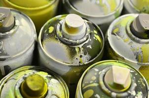 A lot of used spray cans of paint close-up. Dirty and smeared cans for drawing graffiti. The concept of a sweeping and careless drawing of paint. Creative art image photo